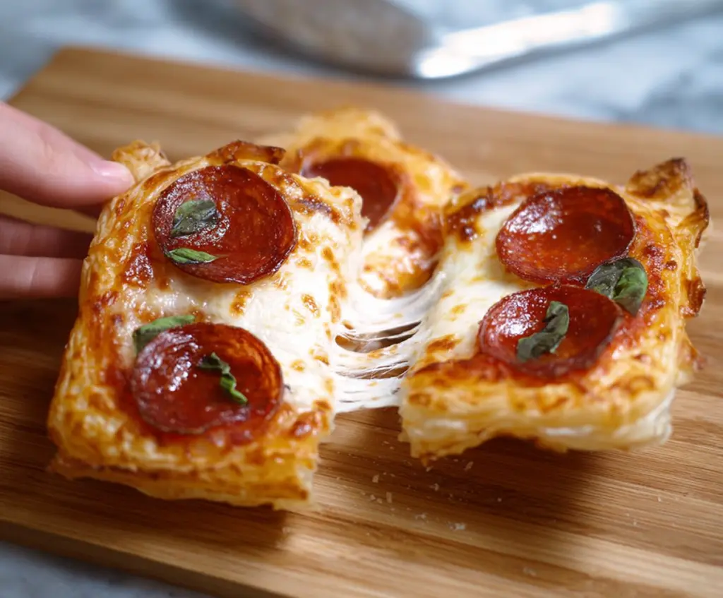 Golden puff pastry pizzas topped with cheese and vegetables, perfect for snack or appetizer.