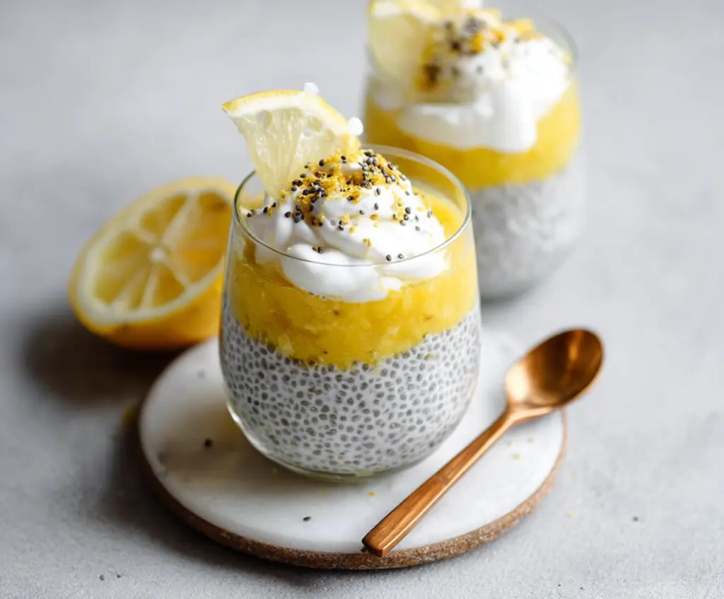 Delicious Lemon Cream Chia Pudding in a glass bowl with fresh lemon slices and chia seeds on top.