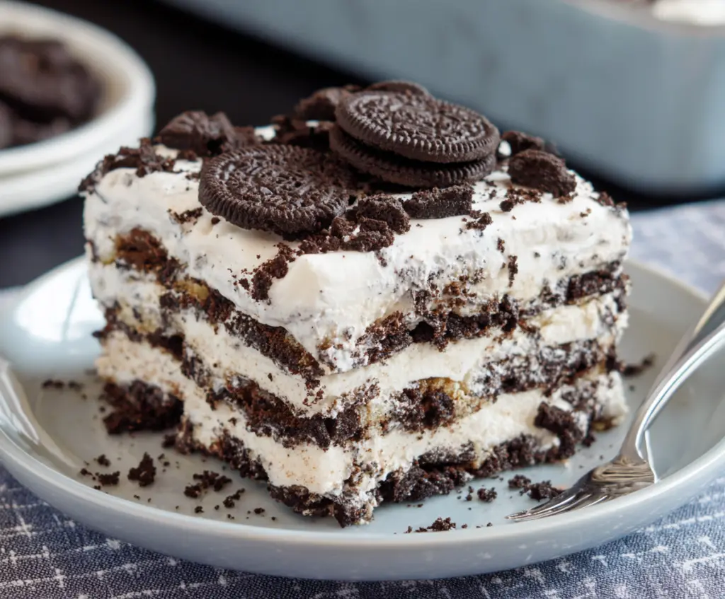 Delicious No Bake Oreo Icebox Cake layered with creamy filling and crunchy Oreo cookies in a glass dish.